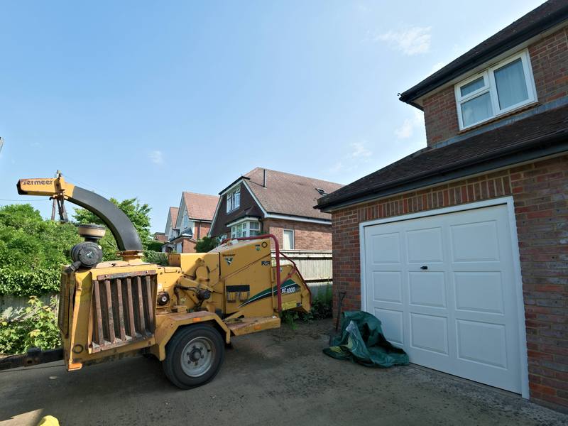 Wood chipper on a tidy domestic driveway at the end of a tree surgery visit
